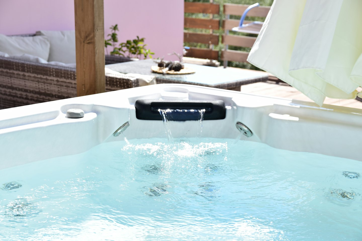 Bubbling outdoor hot tub with a small waterfall feature.