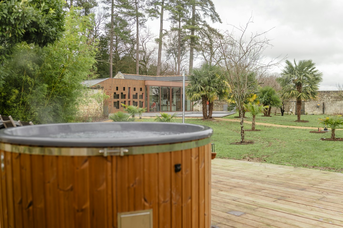 Steaming hot tub on a deck overlooking a garden retreat.